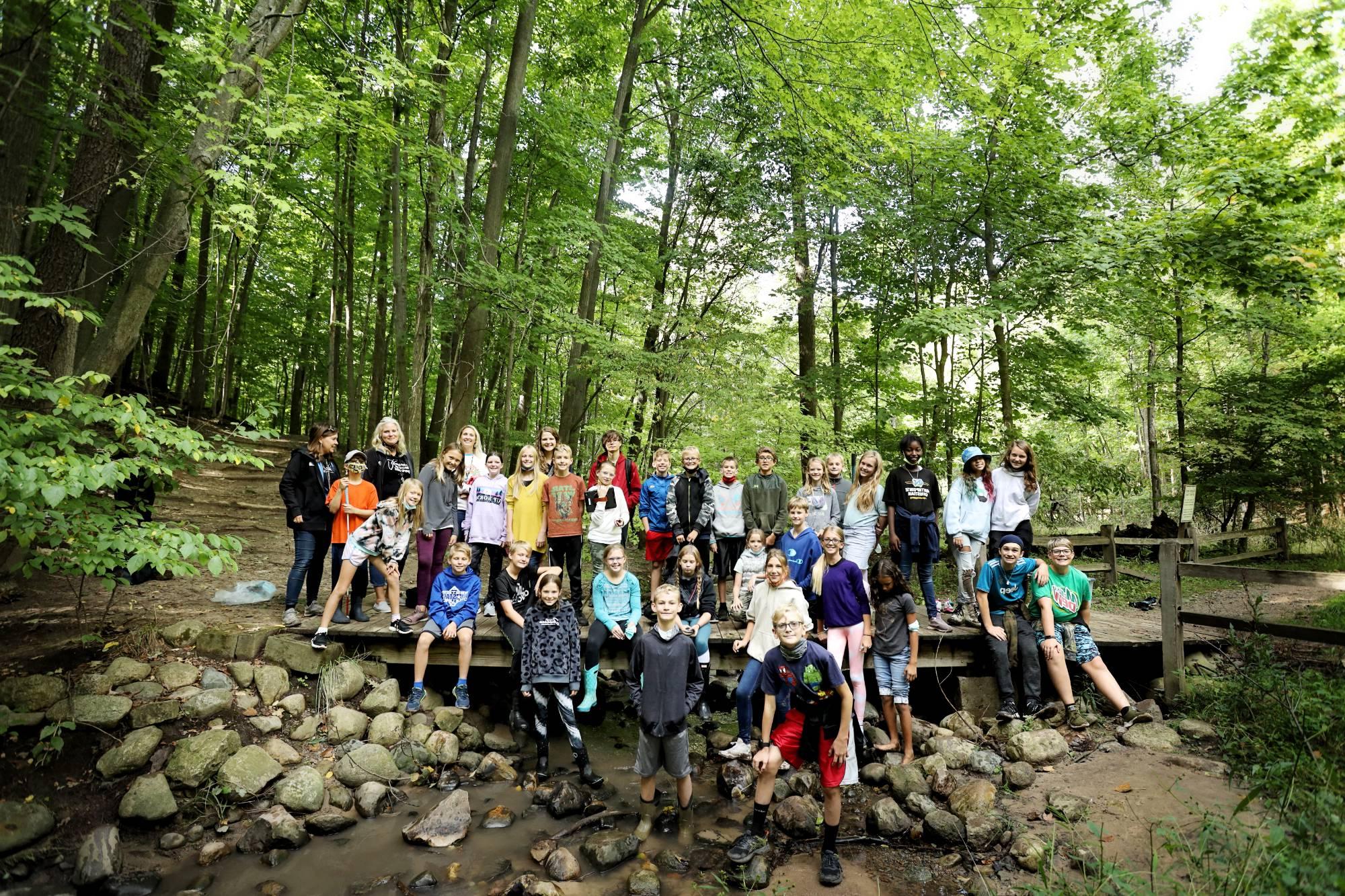 Group of students in the woods completing a Groundswell Action project